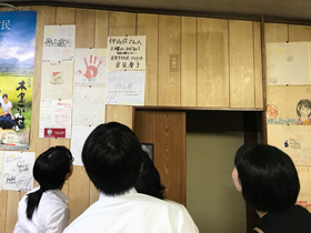 前年度実習生が民宿に残した色紙に見入る実習生