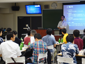 交流会の進行について説明を聞く参加者